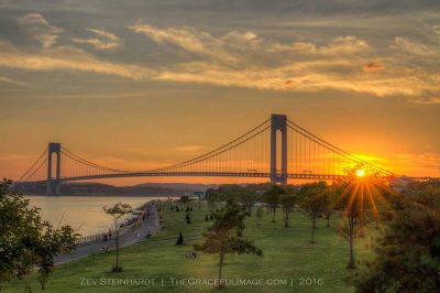 The Verrazano-Narrows Bridge at sunset in July, with Shore Park in the foreground.